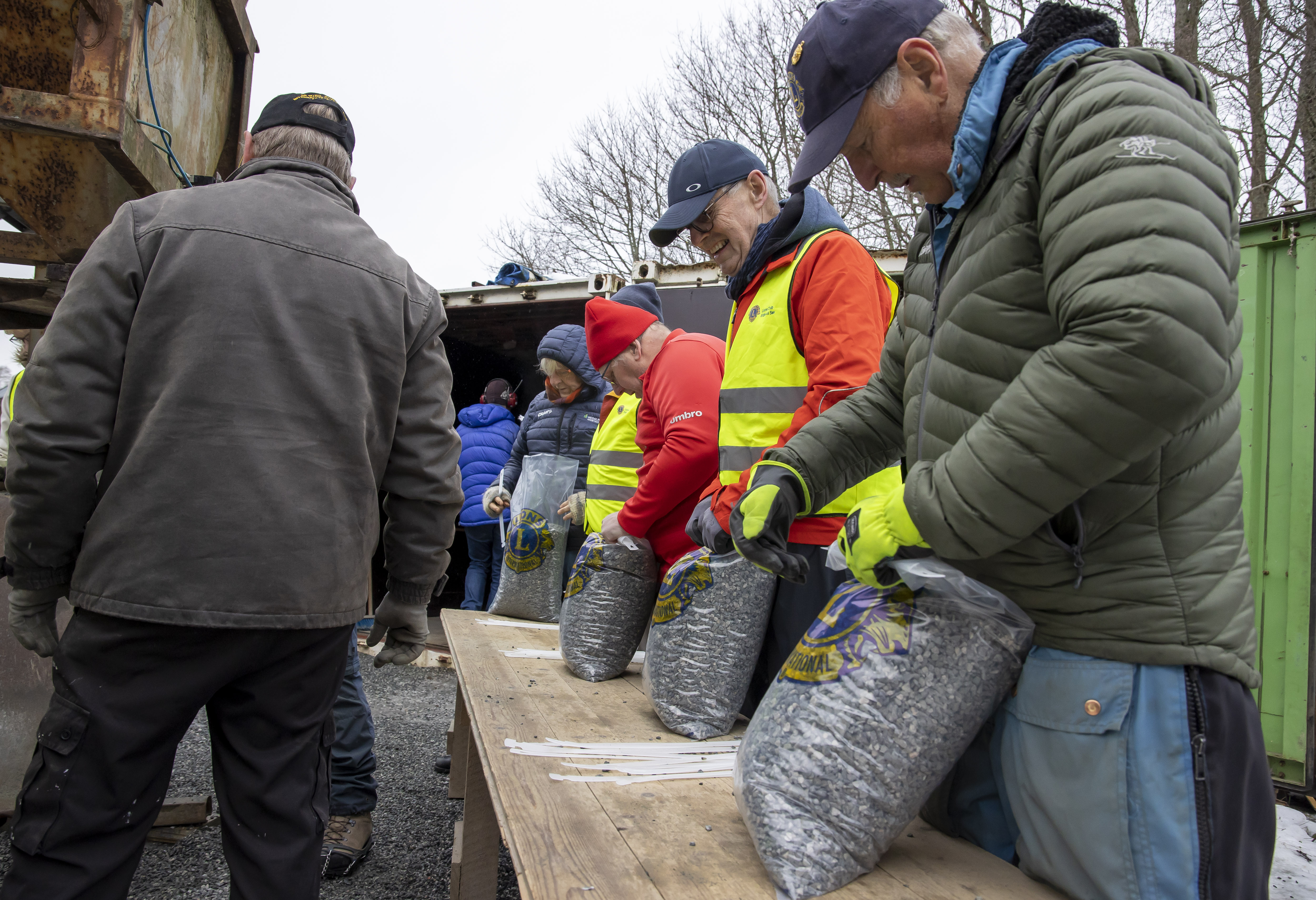 Rundt 800 sekker med singel ble pakket. Snart 87 år gamle Einar Kjøren nærmest kamera