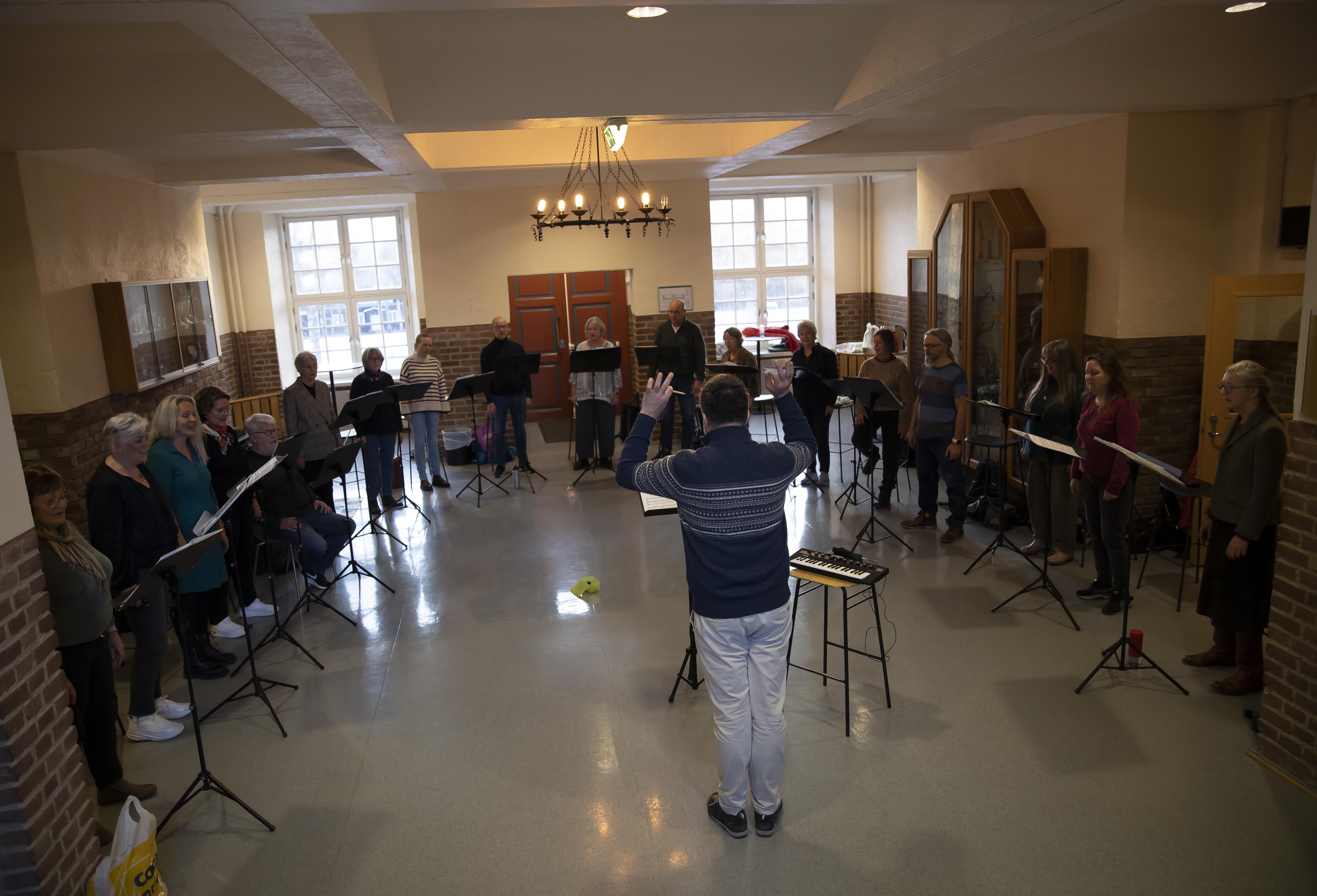 Romerike vokalensemble øver den gamle vestibylen på Eidsvoll videregående skole. I bakgrunnen ser vi hovedinngangen til Eidsvoll landsgymnas Romerike vokalensemble øver den gamle vestibylen på Eidsvoll videregående skole. I bakgrunnen ser vi hovedinngangen til Eidsvoll landsgymnas