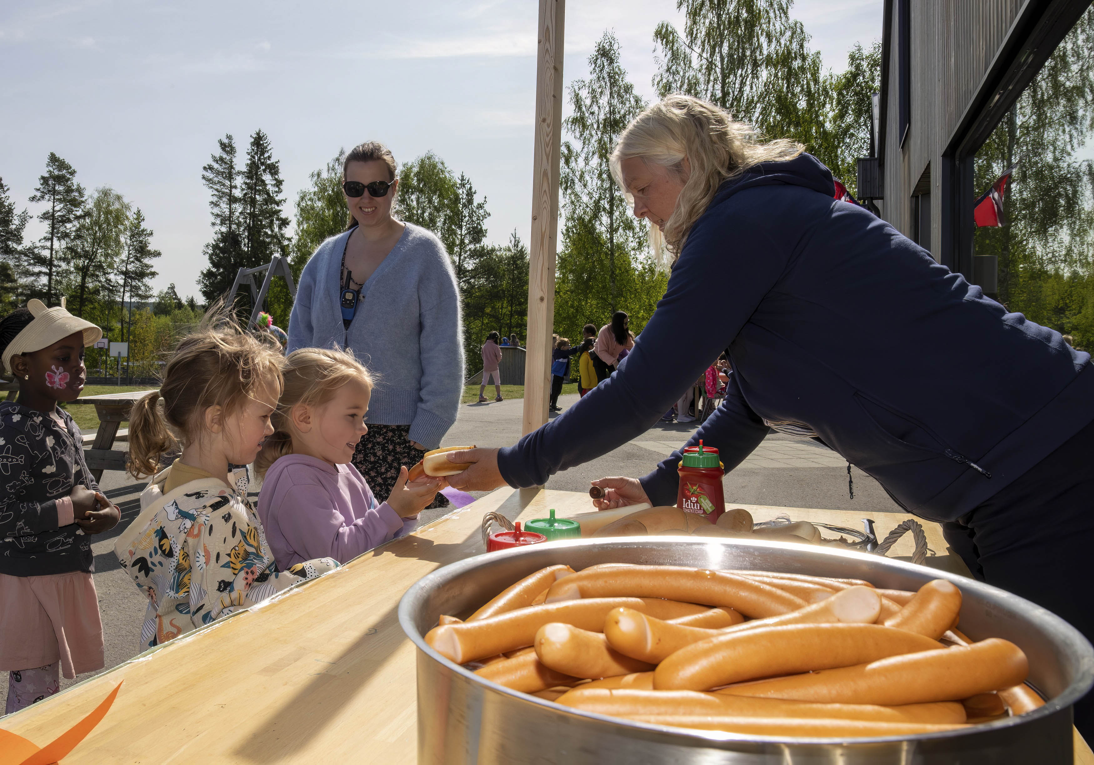 Her står 4-åringene Ore Obadina, Iben Bjørklund, og Emeline Alaska Medalen i pølsekø