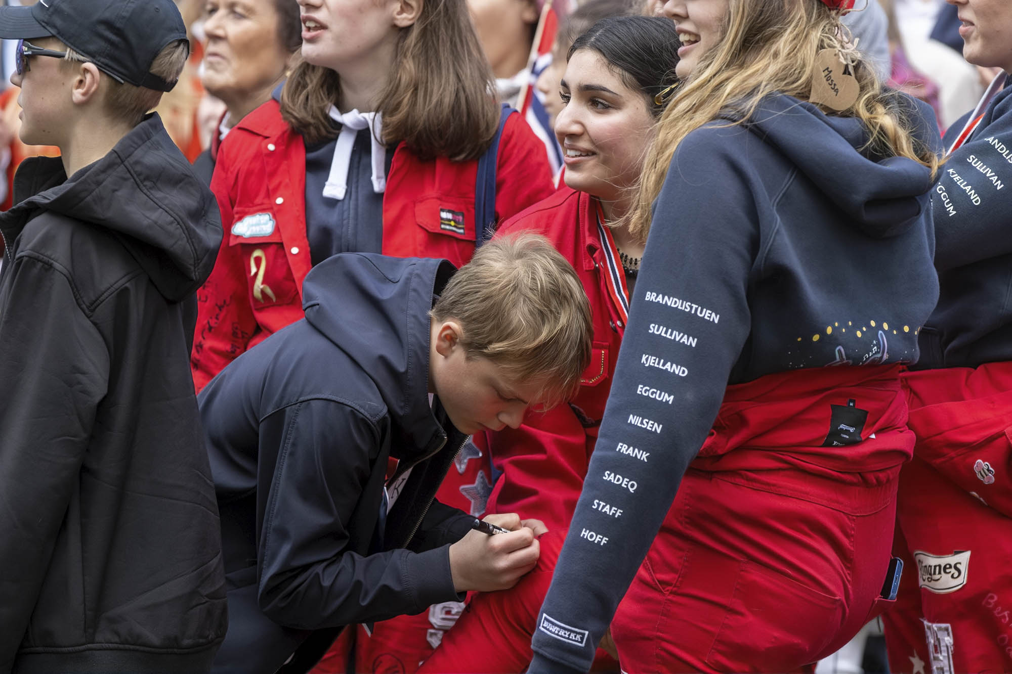 Sander og Cato i Black Helicopter måtte skrive autografer etter konserten. Her får en russ signaturen til Sander på russedressen.